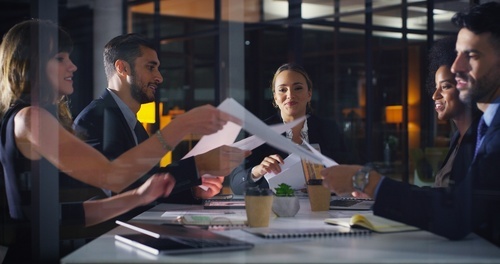 People swapping paper in meeting