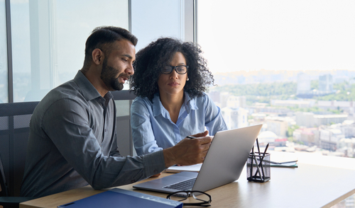 Two people working on a laptop